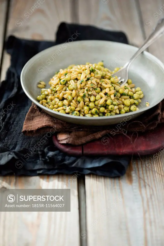 Bowl of kamut and peas on cloth and wood