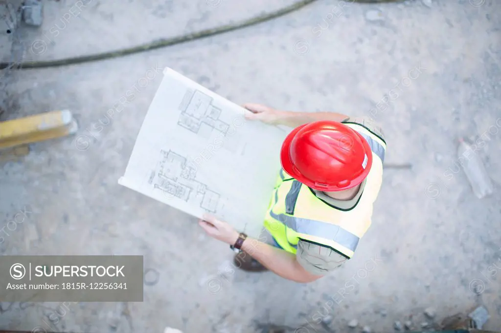 Construction worker reading plan at construction site