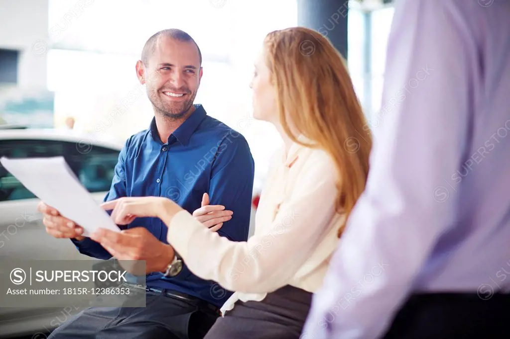 Couple at car dealer buying new car