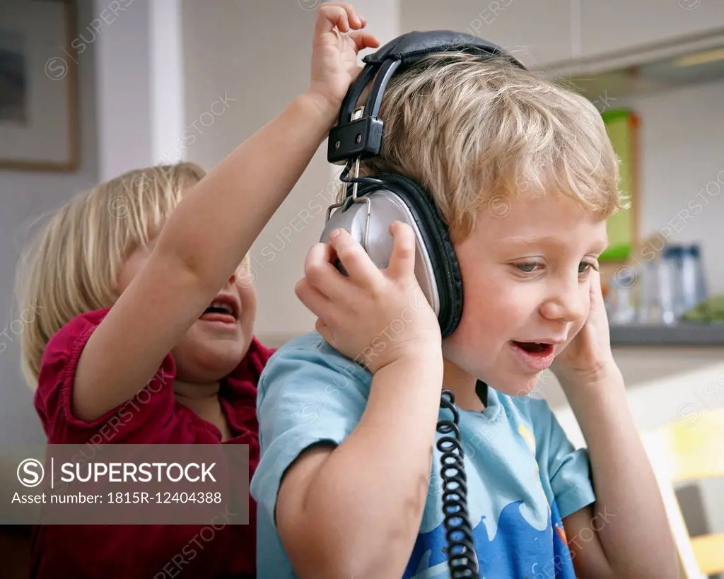 Brother and sister listening to music with headphones