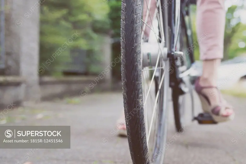 Close-up of woman with wedges on bicycle