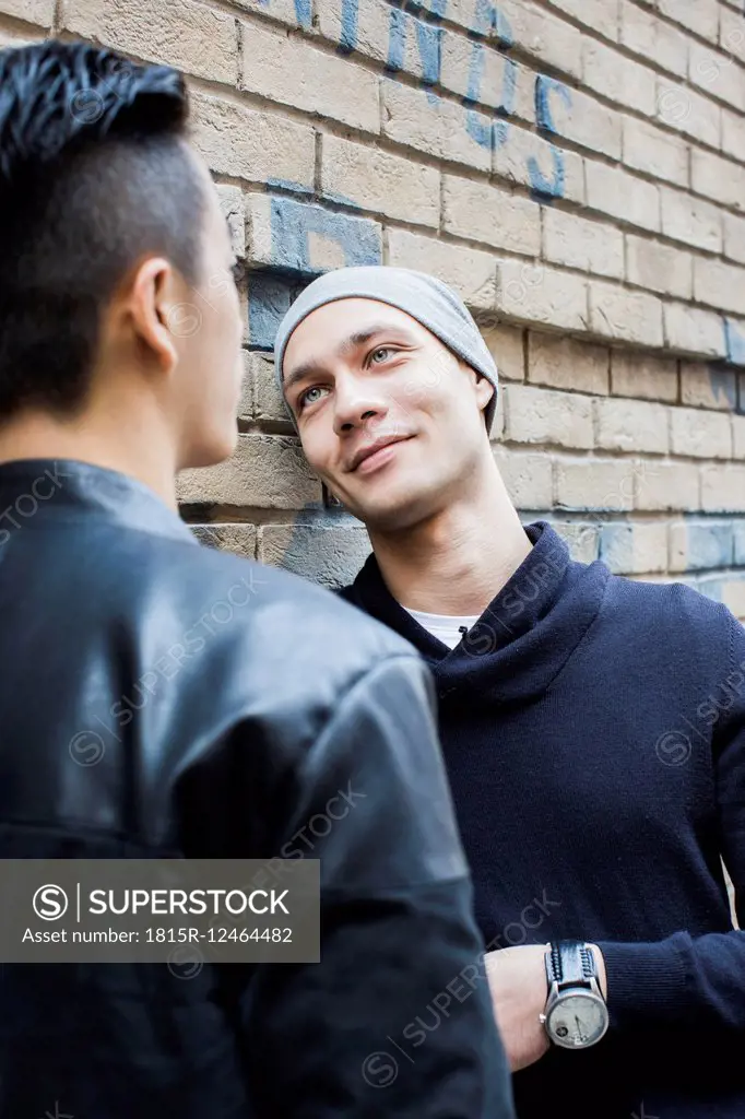 China, Hong Kong, gay couple at house wall