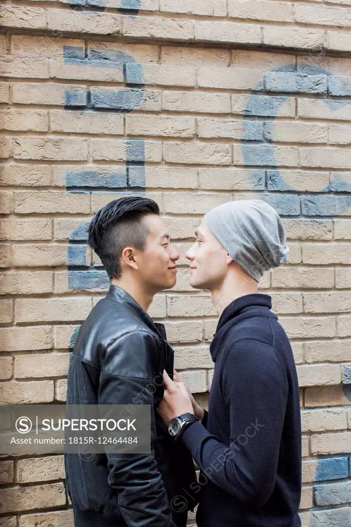 China, Hong Kong, gay couple at house wall