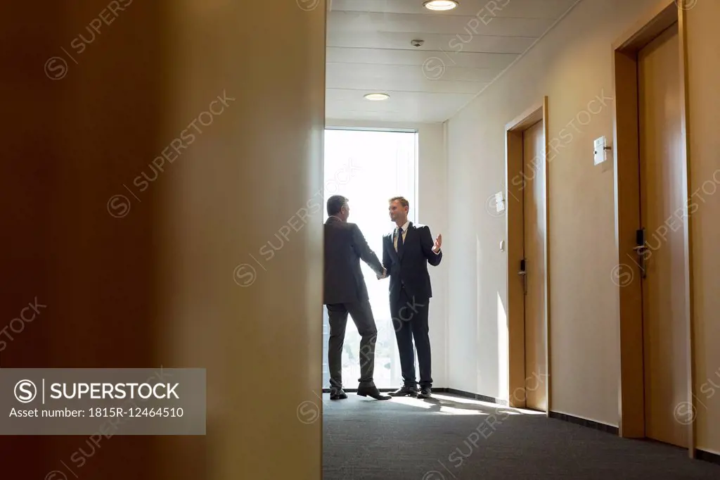 Businesspeople in corridor shaking hands