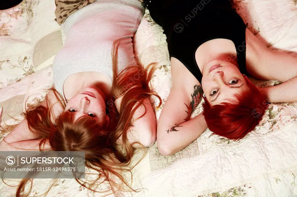 Portrait of two female friends relaxing on a blanket at home