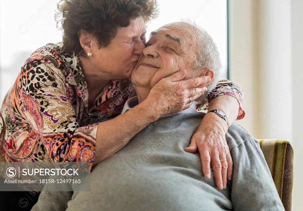 Senior woman hugging and kissing his husband