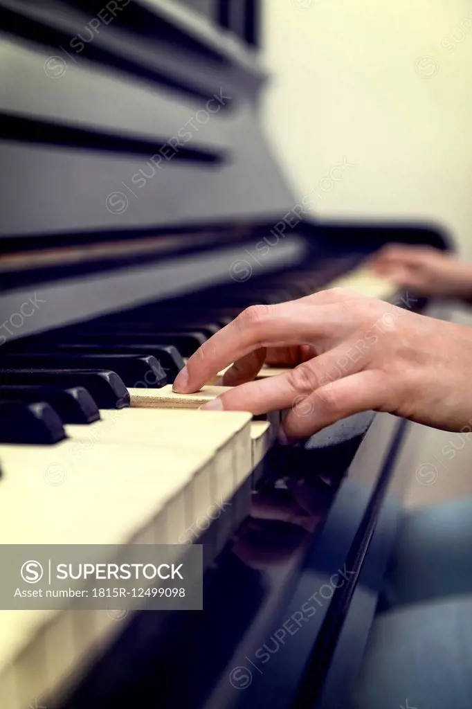 Hands of woman on old piano