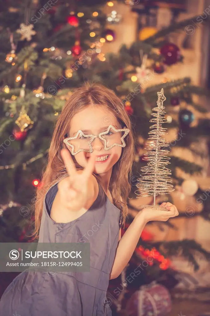 Portrait of happy little girl in front of Christmas tree