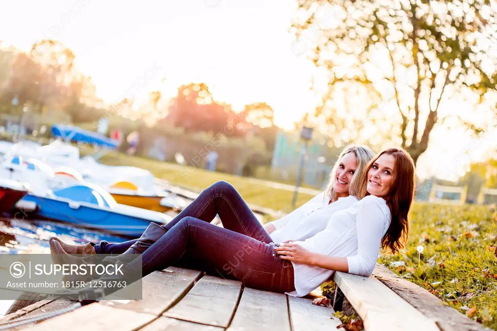 Lesbian couple sitting on boardwalk