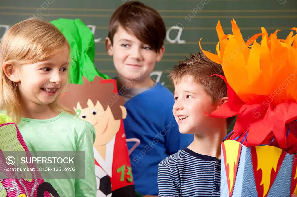 Happy pupils with school cones at blackboard