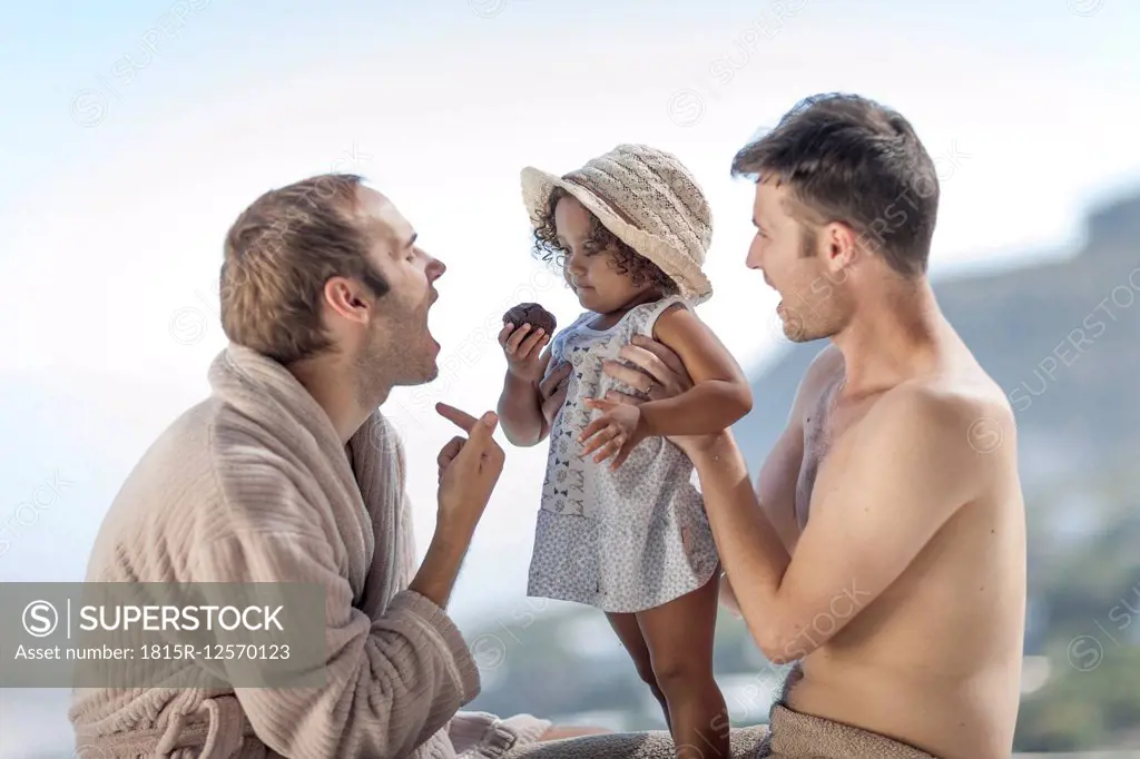 Gay couple with daughter outdoors