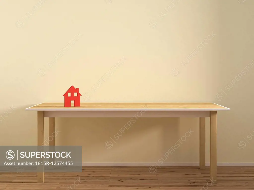 House model on empty table against plain wall