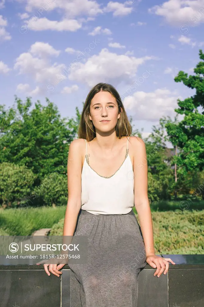 Young woman sitting on a wall