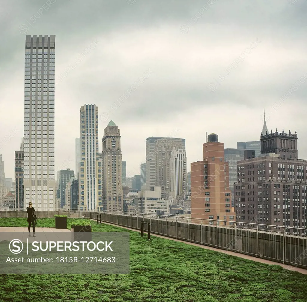 USA, New York City, Woman photographing skyline of Manhattan