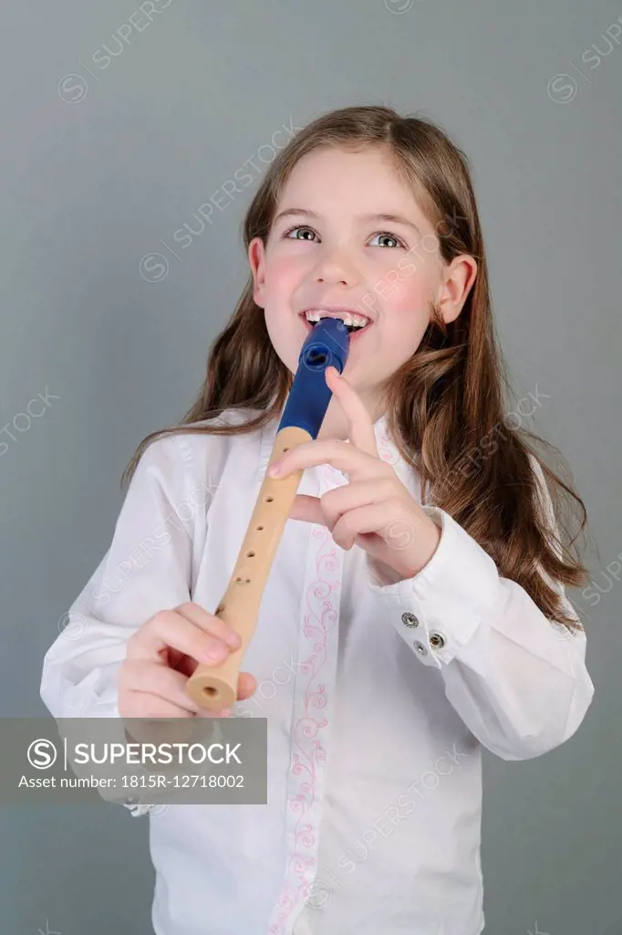 Portrait of little girl playing recorder