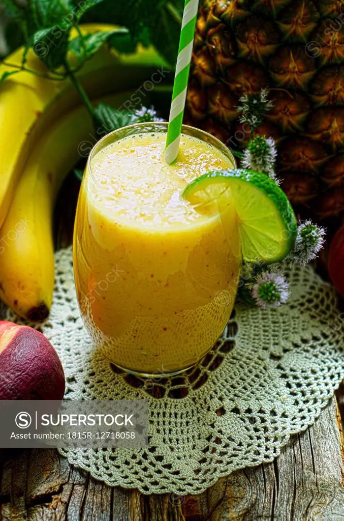 Smoothie of bananas, pineapple and mint on a wooden table