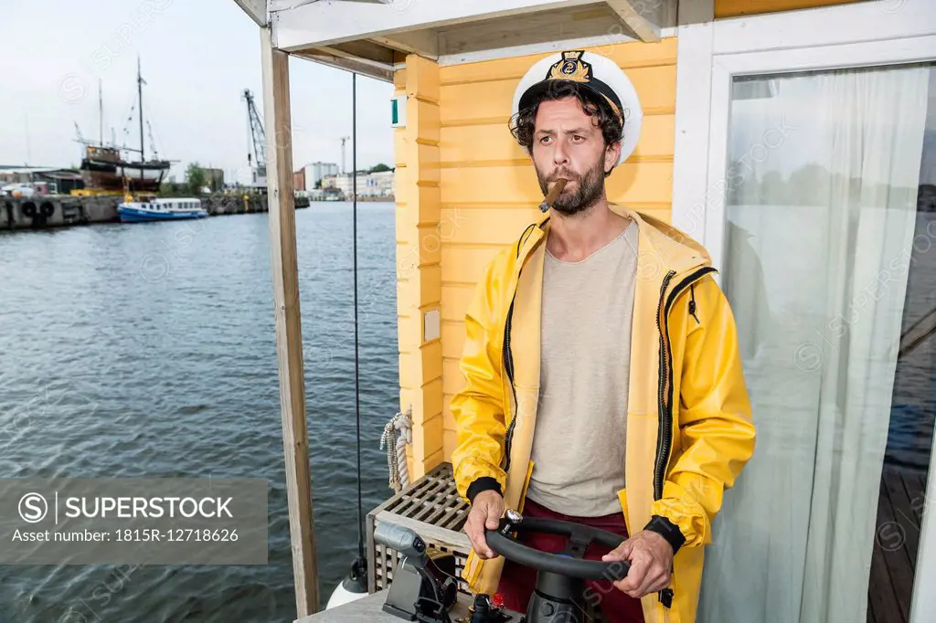 Captain with cigar steering hpuse boat