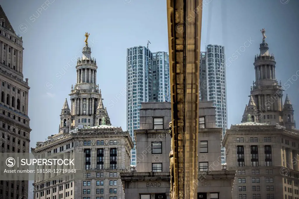 USA, New York City, Highrise building mirrored in glass facade