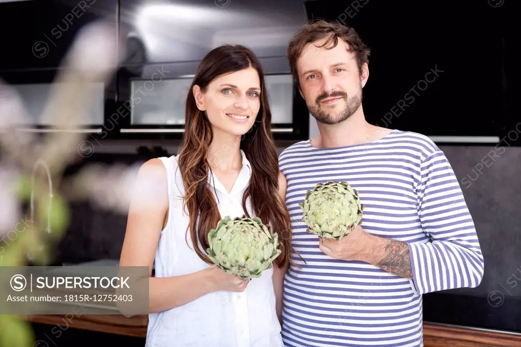 Portrait of couple holding artichokes