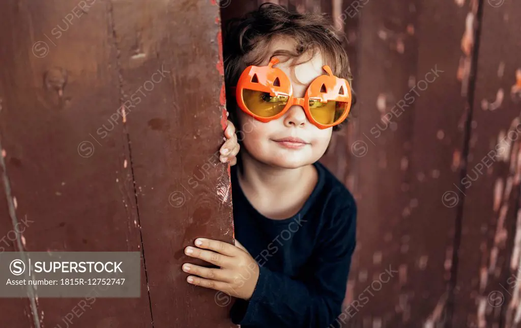Portrait of little girl wearing halloween glasses shaped like pumpkins