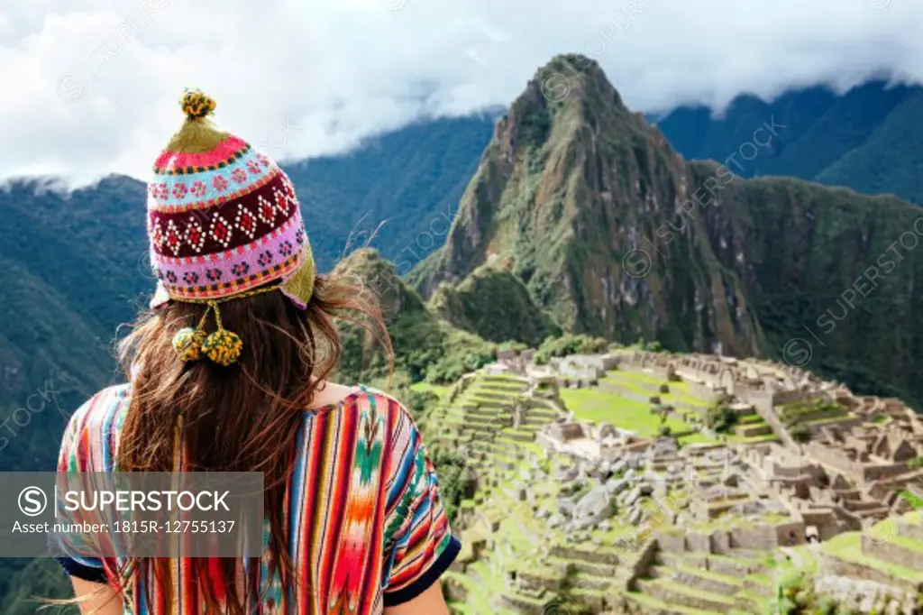 Peru, Machu Picchu region, Female traveler looking at Machu Picchu citadel and Huayna mountain