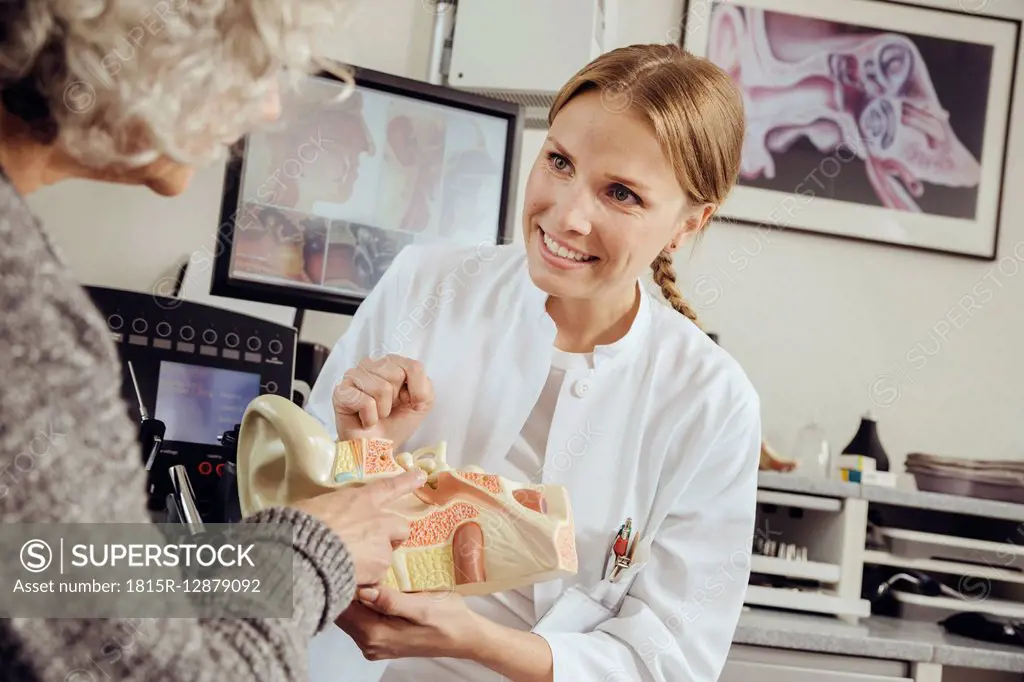 Female doctor explaining functions of the ear according to a model to a patient in her practice