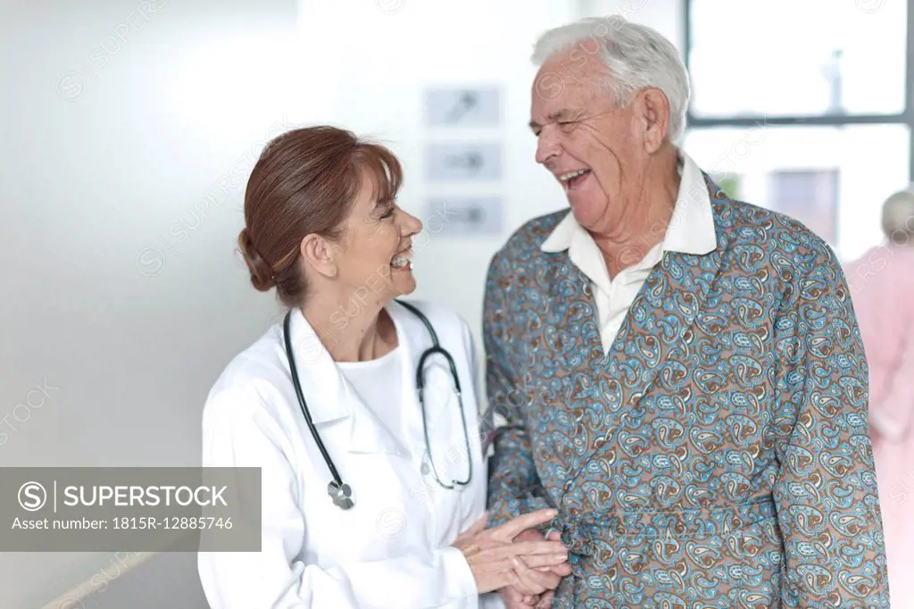 Doctor with happy elderly patient on hospital floor