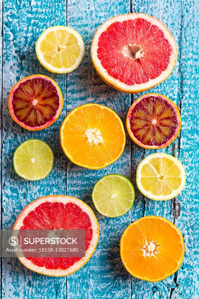 Sliced citrus fruits on light blue wood