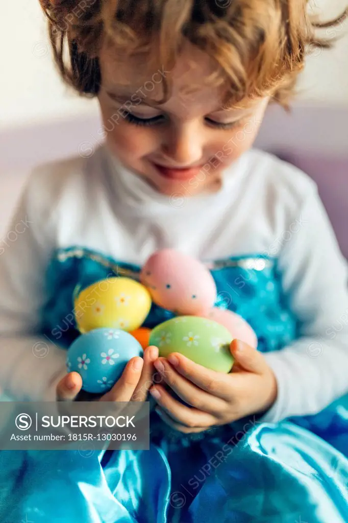Happy little girl holding Easter eggs