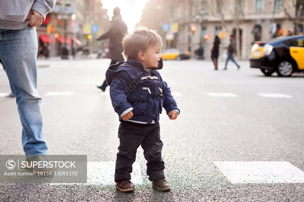 Spain, Barcelona, little boy standing on a road