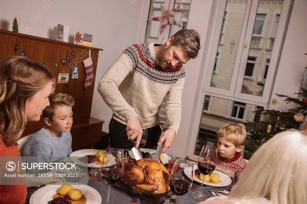 Father cutting the turkey during Christmas dinner