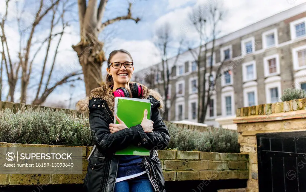 London, student girl with headphone and writing pad, language holiday