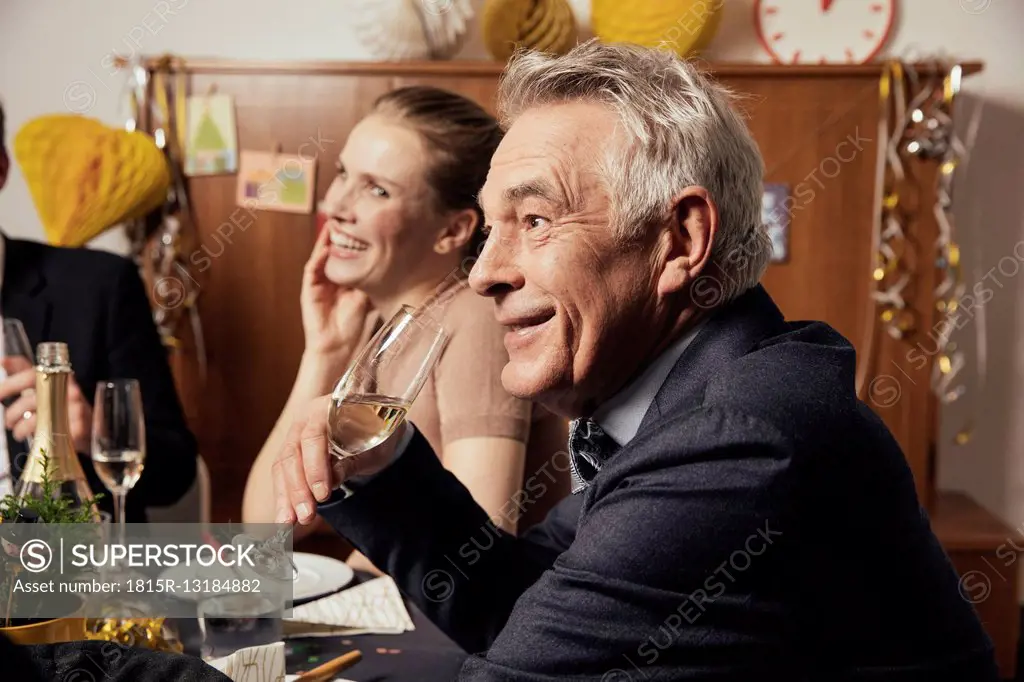 Senior man drinking champagne at New Yera's Eve party