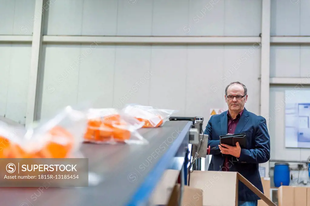 Manager checking packaging of goods in plastics factory