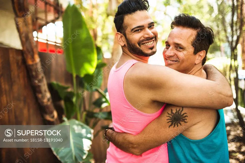 Portrait of happy gay couple arm in arm