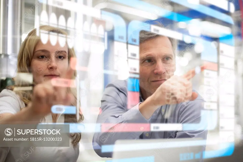 Man and woman using transparent touchscreen device