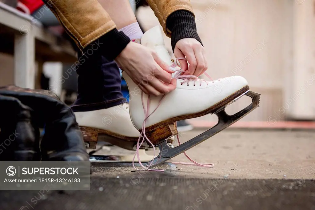 Close-up of woman putting on ice skates