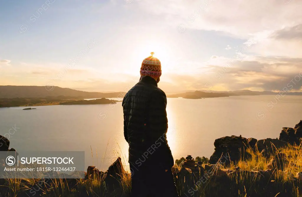 Peru, Amantani Island, back view of man enjoying sunset from Pachamama peak