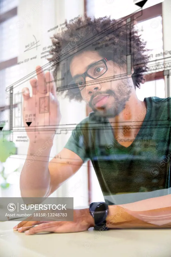 Young man using transparent touchscreen display