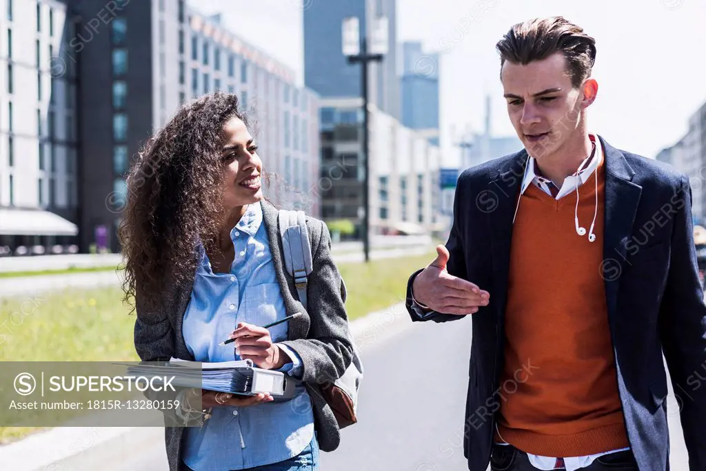 Young man and woman talking outdoors