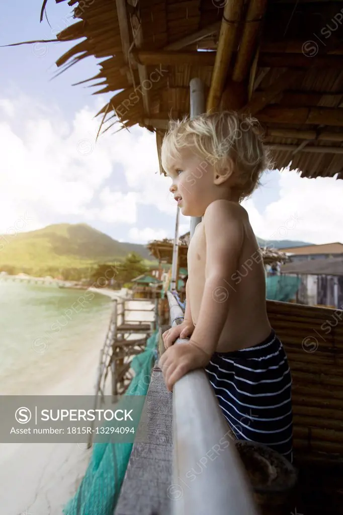 Thailand, toddler in a in beach hut looking at distance