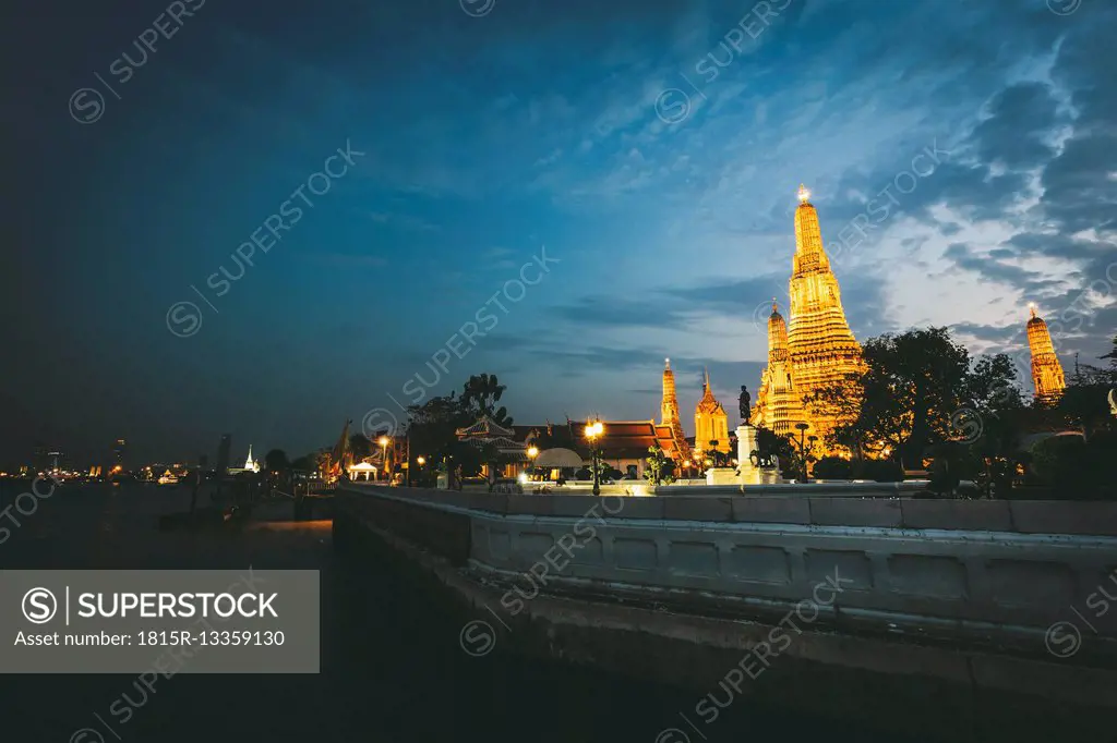 Thailand, Bangkok, Wat Arun at twilight with Chao Praya River in the foreground