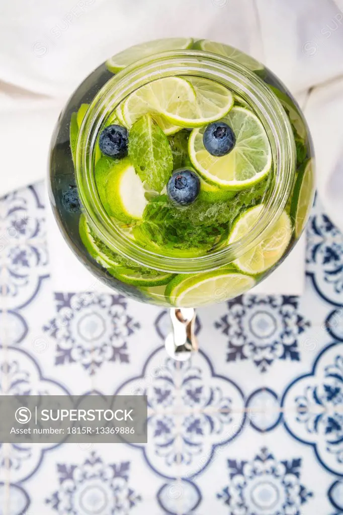 Glass of infused water with lime, blueberries and mint