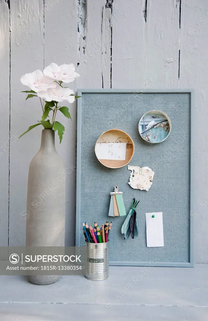 Mood board with photos,coloured pencils, hibiscus blossoms, vase