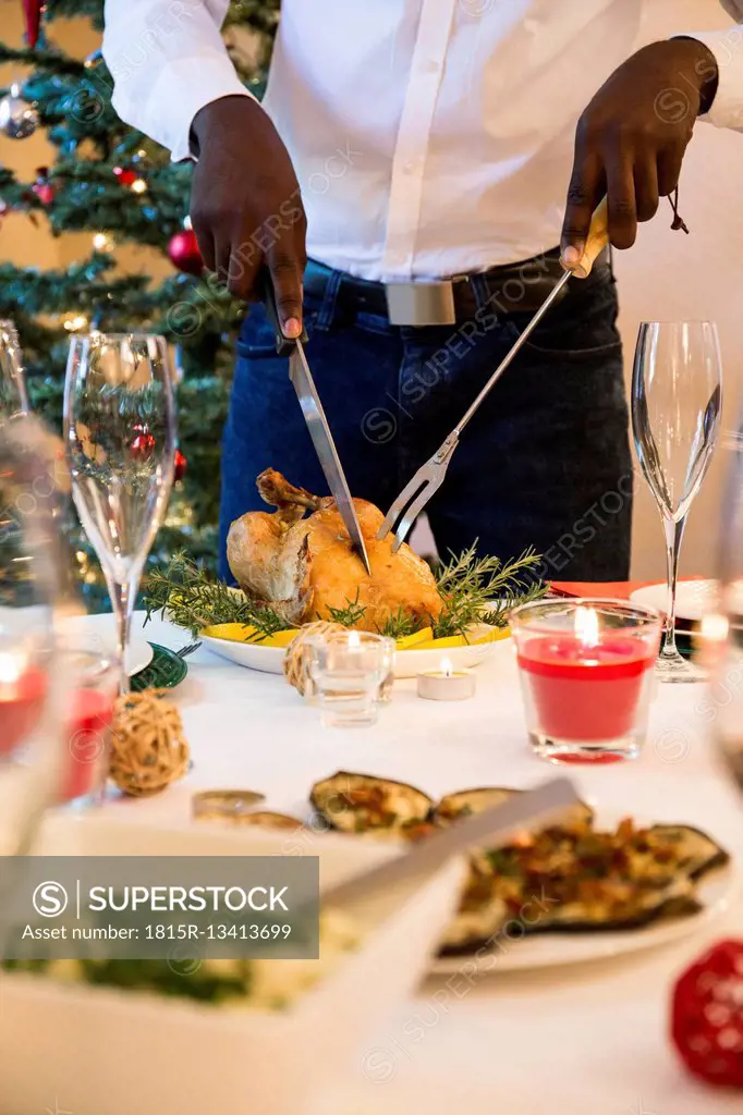 Man carving a roast chicken for Christmas dinner