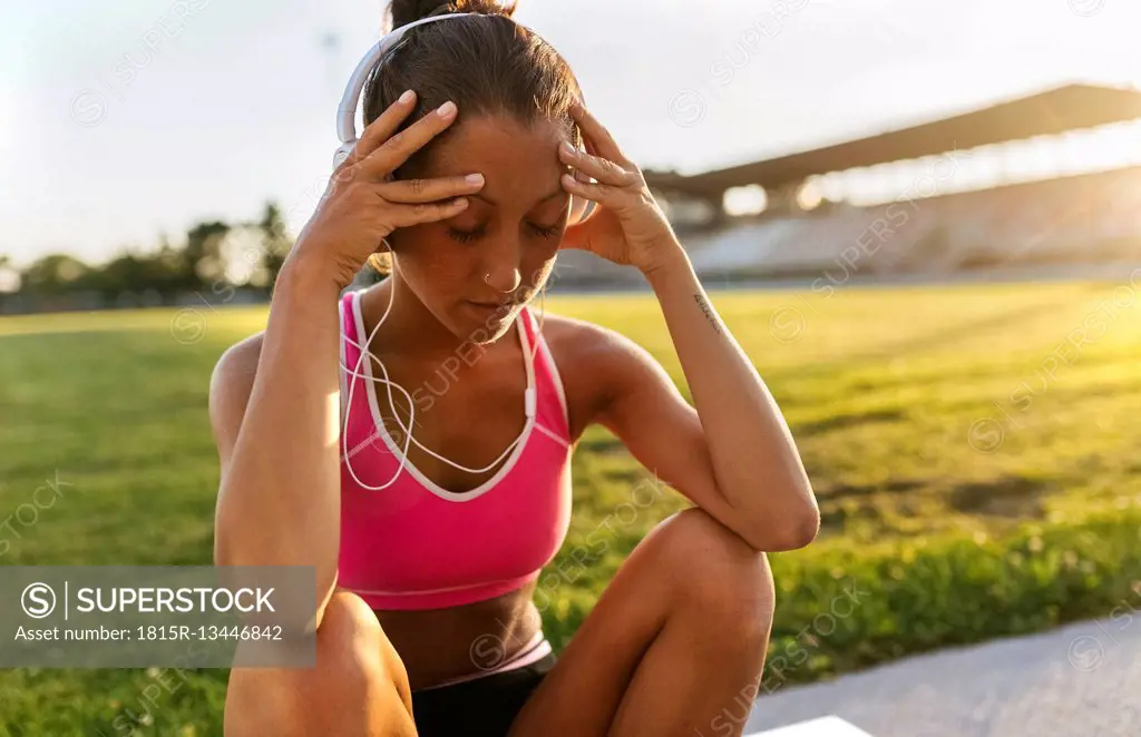 Female athlete taking a break, listening to music