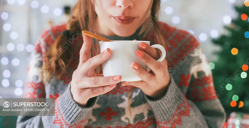 Woman with cup of coffee at Christmas time, close-up