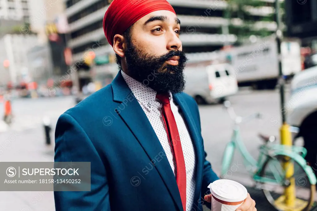 Indian businessman walking in Manhattan, drinking coffee