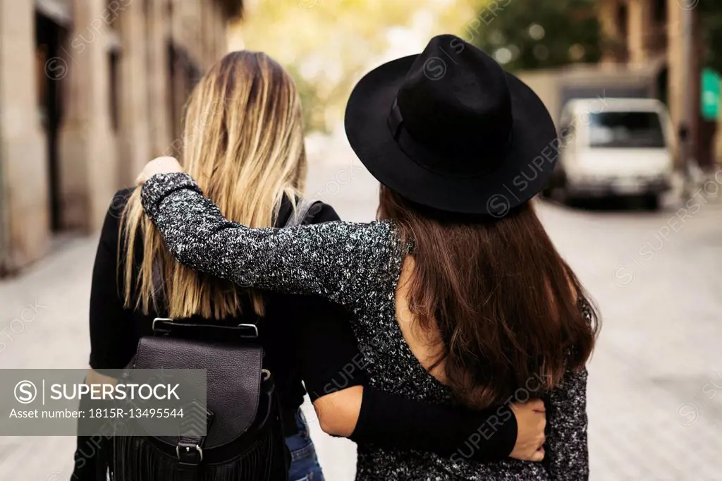 Back view of two women walking on the street