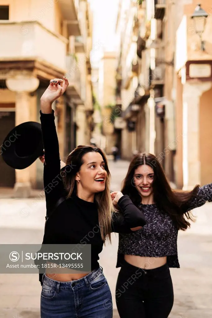 Two happy best friends dancing on the street